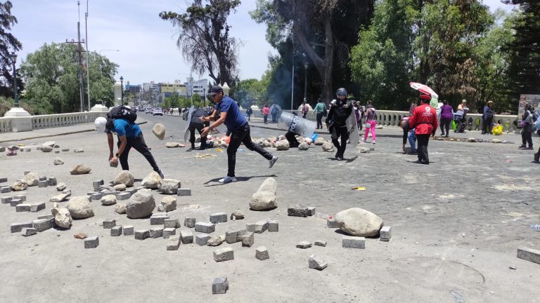 Ciudadanos ayudan a retiran piedras que bloqueaban el tránsito en el puente Grau