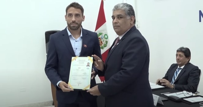 Cristian Bordacahar con el título de nacionalidad peruana.